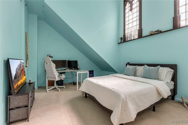 bedroom featuring lofted ceiling and carpet