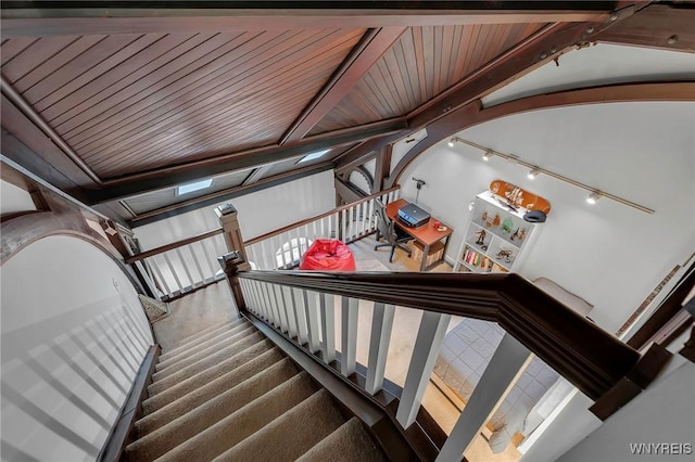 stairs featuring vaulted ceiling with beams