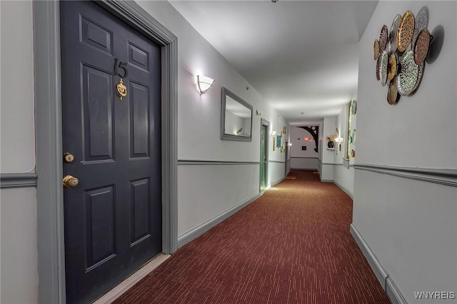 hallway with baseboards and carpet floors