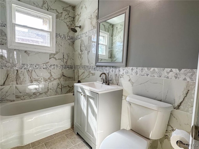 full bathroom featuring vanity, tile walls, toilet, and bathtub / shower combination