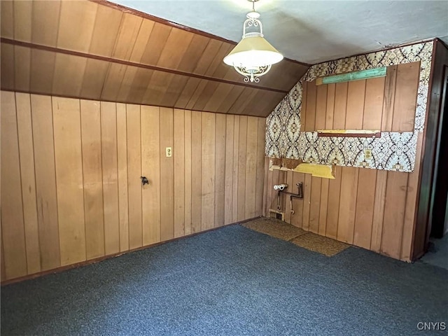 additional living space with vaulted ceiling, wood walls, and carpet floors