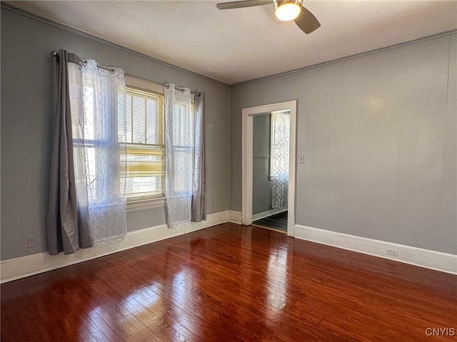 unfurnished room featuring hardwood / wood-style floors, baseboards, and ceiling fan