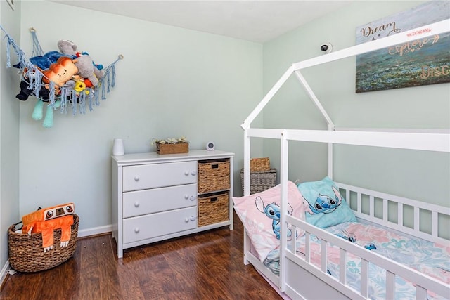 bedroom with baseboards and dark wood-style flooring