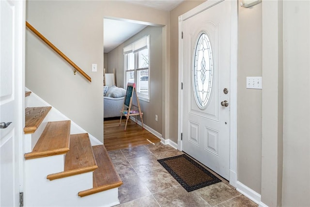 entrance foyer featuring stairway and baseboards