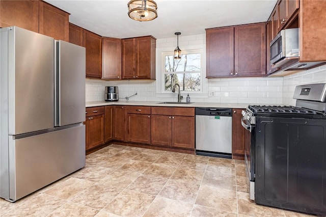 kitchen with light countertops, tasteful backsplash, appliances with stainless steel finishes, and a sink