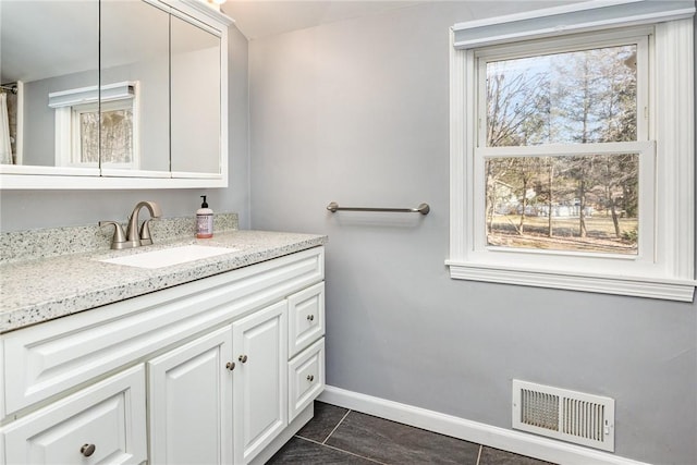 bathroom featuring visible vents, baseboards, vanity, and tile patterned flooring