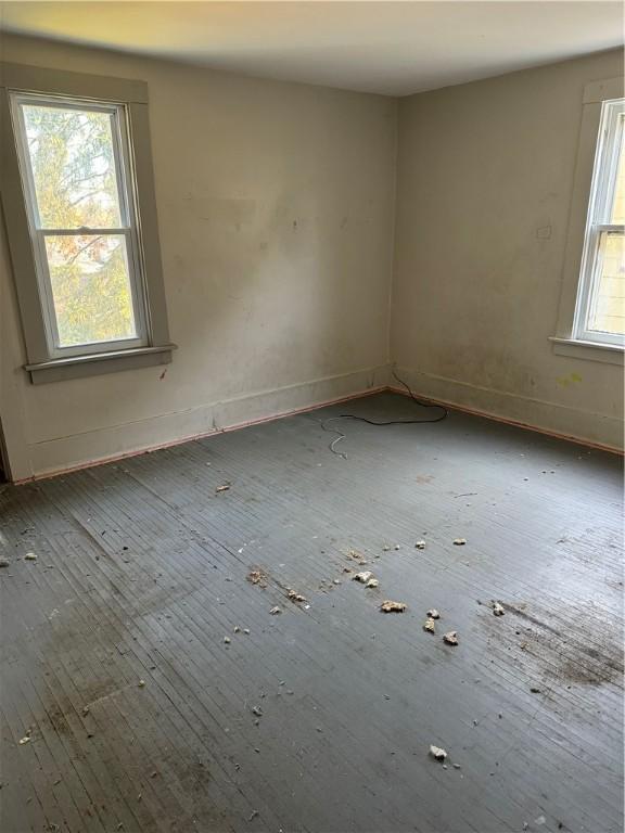 unfurnished room with a healthy amount of sunlight and baseboards