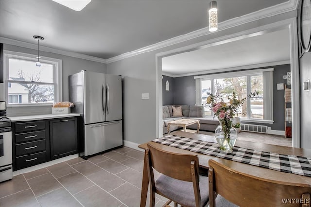 kitchen featuring a healthy amount of sunlight, appliances with stainless steel finishes, light countertops, and crown molding