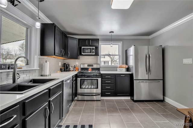 kitchen with light countertops, ornamental molding, decorative backsplash, stainless steel appliances, and a sink