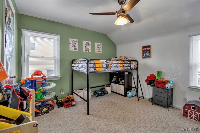 carpeted bedroom featuring lofted ceiling, baseboards, and ceiling fan