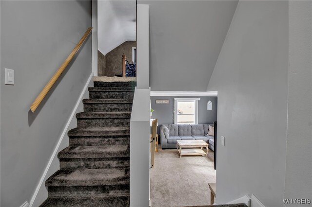 staircase with carpet floors and lofted ceiling