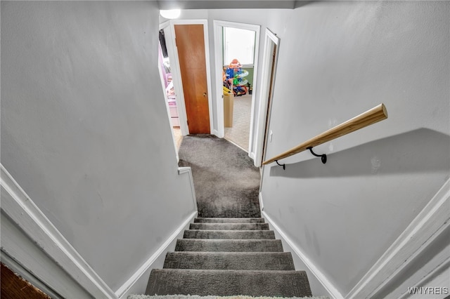 stairs featuring baseboards and carpet floors