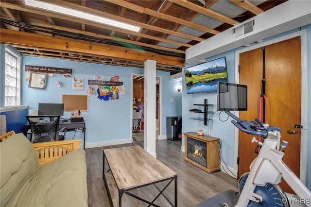 living area with visible vents, baseboards, and wood finished floors