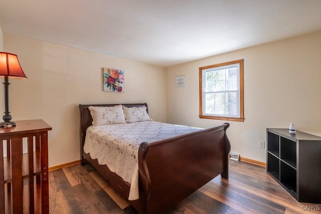 bedroom featuring visible vents, baseboards, and wood finished floors