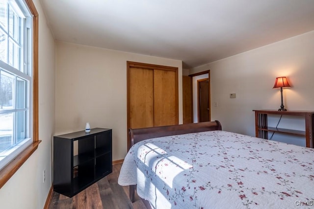 bedroom featuring a closet, baseboards, and dark wood-style floors