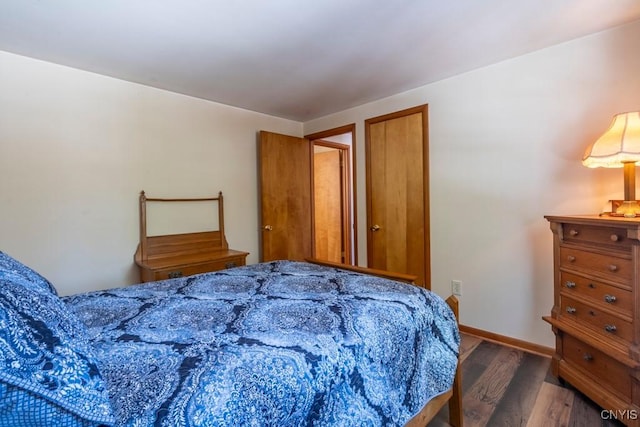 bedroom with baseboards and wood finished floors