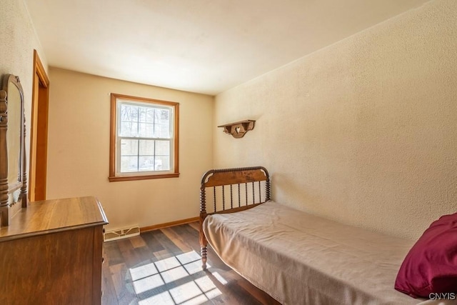 bedroom featuring visible vents, baseboards, and dark wood-type flooring