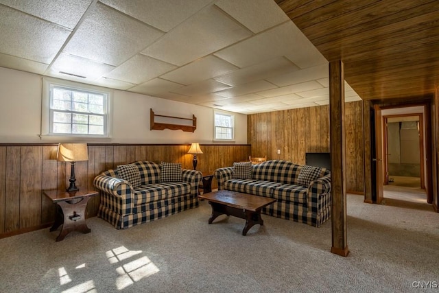 carpeted living room featuring visible vents, wooden walls, and wainscoting