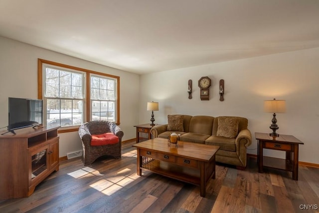 living area featuring wood finished floors, visible vents, and baseboards