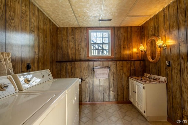 washroom with wooden walls, independent washer and dryer, laundry area, and light floors