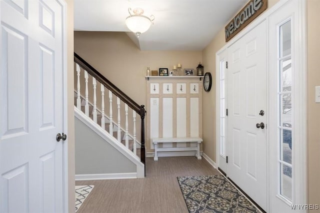 foyer entrance featuring stairway, wood finished floors, and baseboards