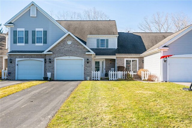 traditional home with brick siding, a front yard, roof with shingles, and driveway