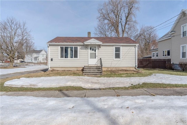 bungalow featuring fence and a chimney