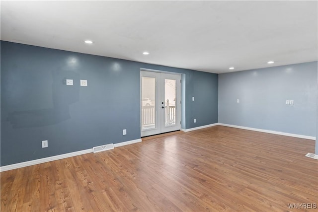 spare room featuring visible vents, baseboards, recessed lighting, french doors, and wood finished floors