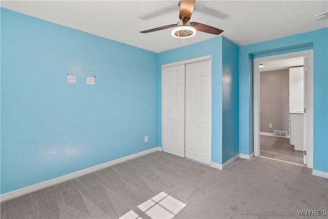 unfurnished bedroom with carpet, visible vents, a closet, and baseboards