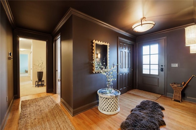 foyer with baseboards, wood finished floors, and crown molding