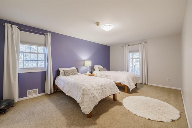 carpeted bedroom featuring visible vents and baseboards