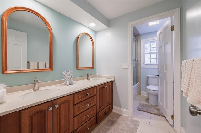 full bath with tile patterned floors, double vanity, toilet, and a sink