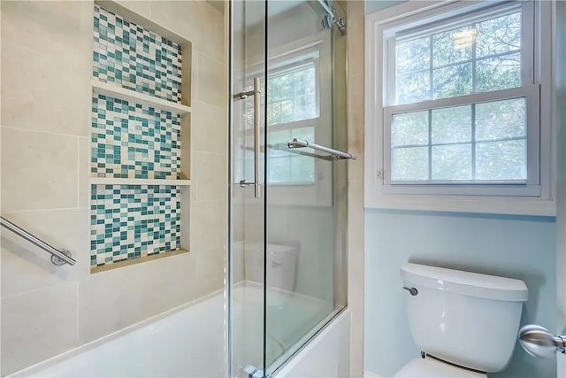 full bathroom featuring toilet and combined bath / shower with glass door