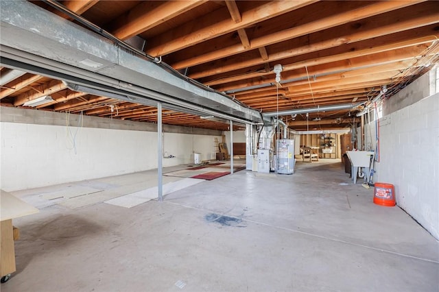 unfinished below grade area featuring a sink and water heater