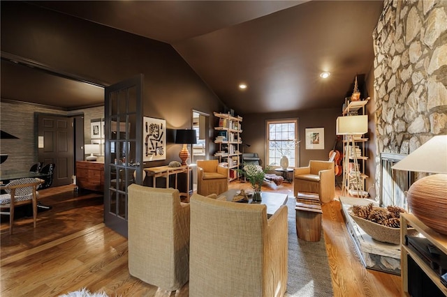 living area featuring wood finished floors, a fireplace, and vaulted ceiling