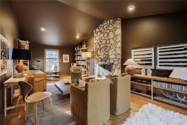 living room with a fireplace, lofted ceiling, and wood finished floors