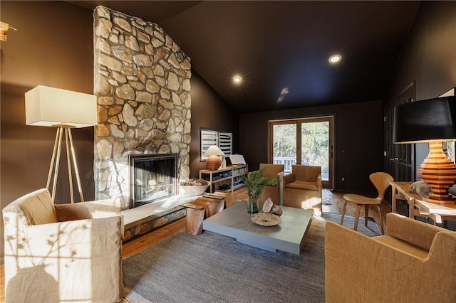 living area featuring lofted ceiling, wood finished floors, a fireplace, and recessed lighting