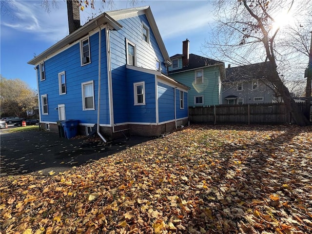 back of property featuring fence and a chimney