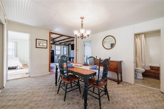 dining space with a notable chandelier and light colored carpet