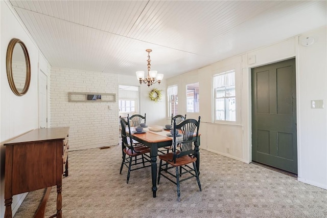 dining space featuring plenty of natural light, brick wall, and carpet flooring