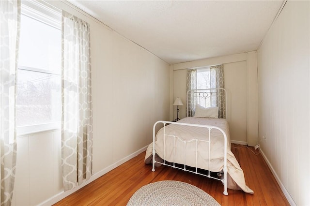 bedroom featuring wood finished floors and baseboards