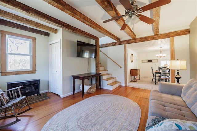 living room featuring beam ceiling, stairs, baseboards, and wood finished floors