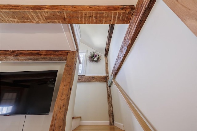 staircase featuring baseboards and wood finished floors