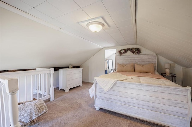 bedroom featuring light colored carpet and vaulted ceiling