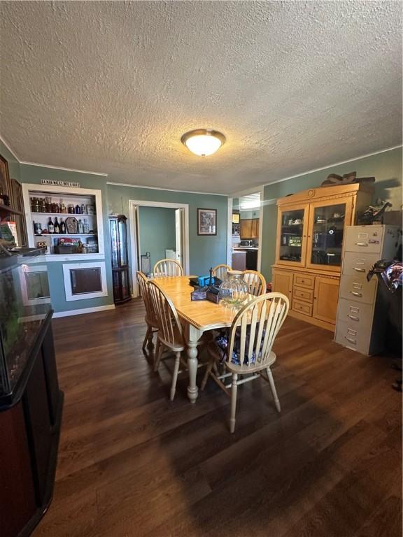 dining area featuring a textured ceiling and dark wood-type flooring