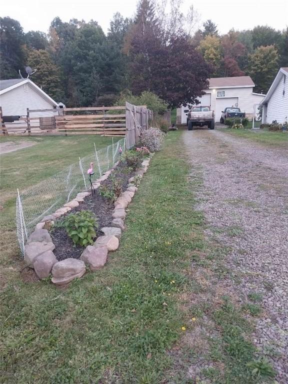 view of yard featuring fence and driveway