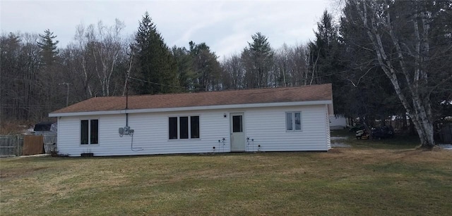 exterior space featuring a forest view, a front yard, and fence