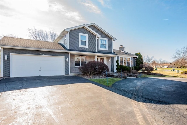 traditional home featuring brick siding, an attached garage, and driveway