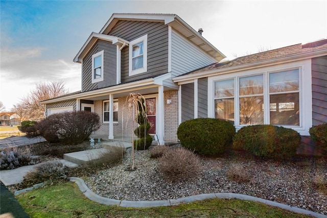 view of front of home featuring covered porch and brick siding