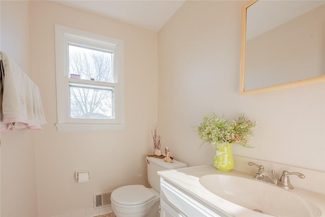 bathroom featuring visible vents, toilet, and vanity